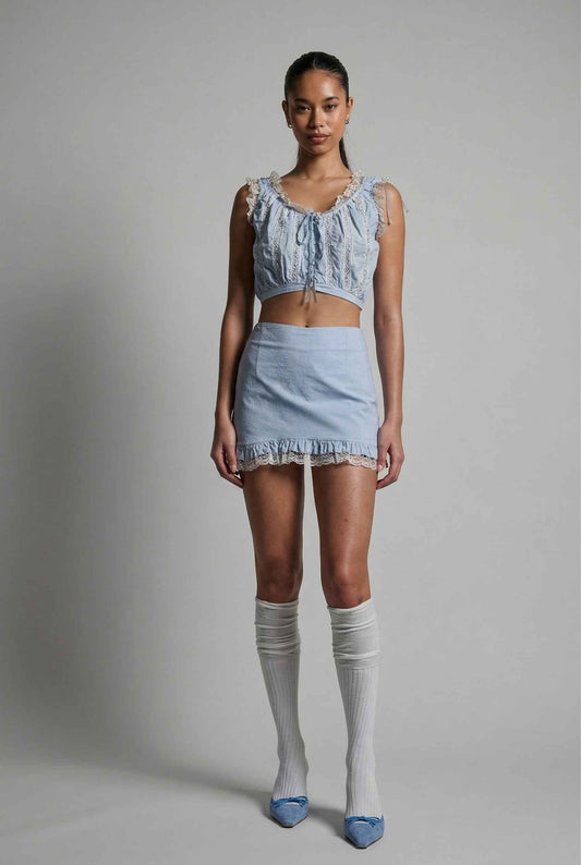 Model wearing Skye Skirt in Light Blue Cotton Mini Skirt with Delicate Lace Trim paired with matching top and heels with knee stockings