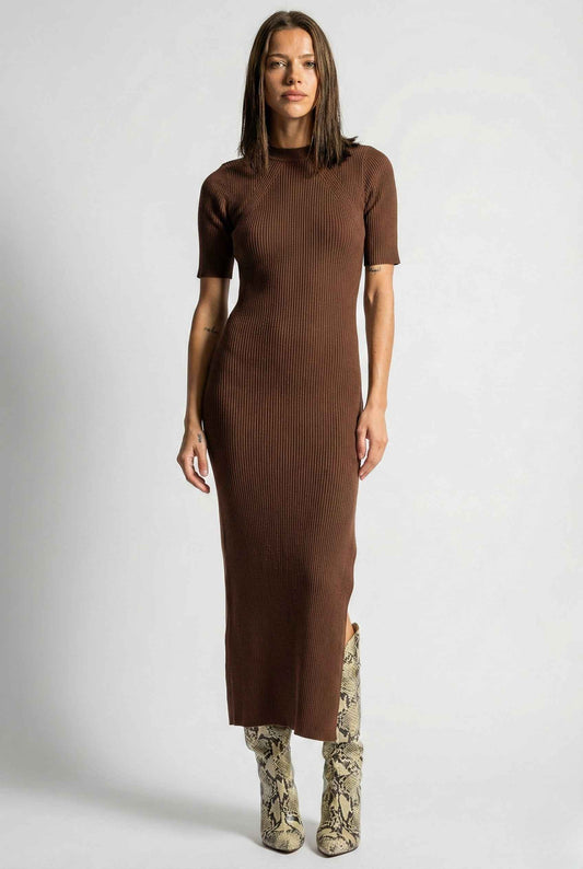 Woman wearing a Sloane Midi Brown Ribbed Short Sleeve Dress with patterned boots on a white background