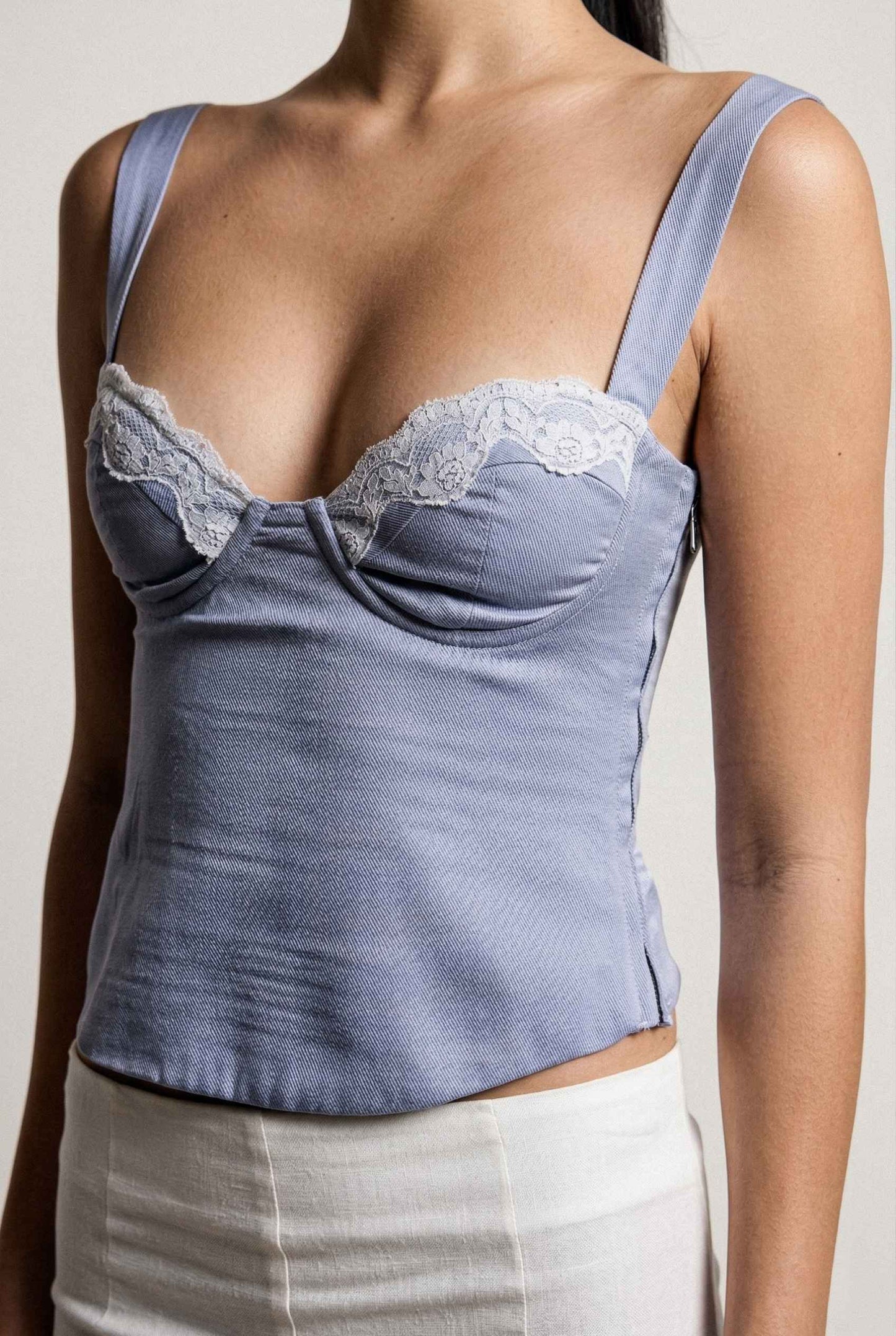 Sophie Top Blue Pastel Satin Corset Cami with White Lace Trim worn by a person on a plain background