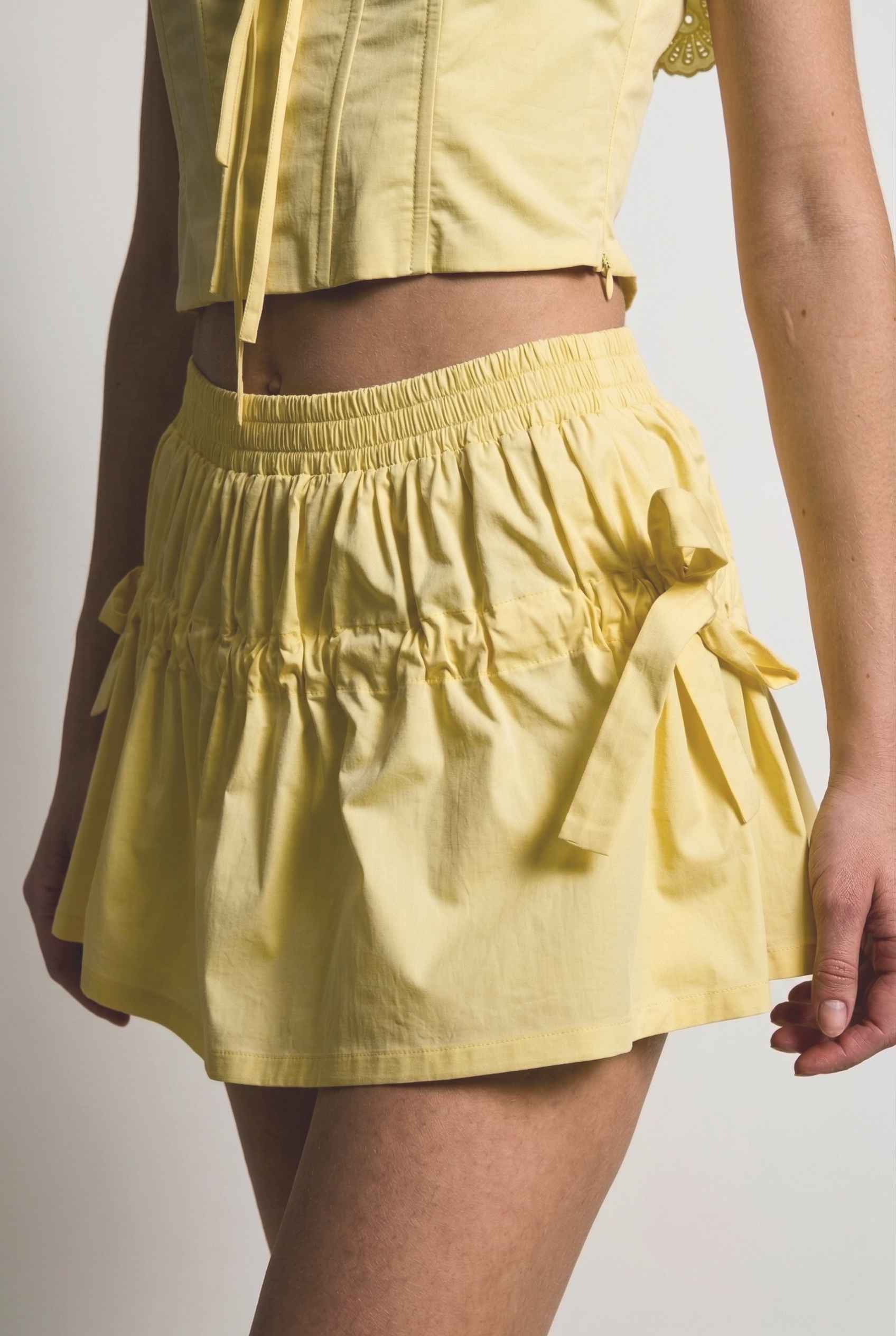 Sunnie Skirt in Soft Yellow Poplin Mini Skirt with Bows paired with matching ruffle top close up bow details