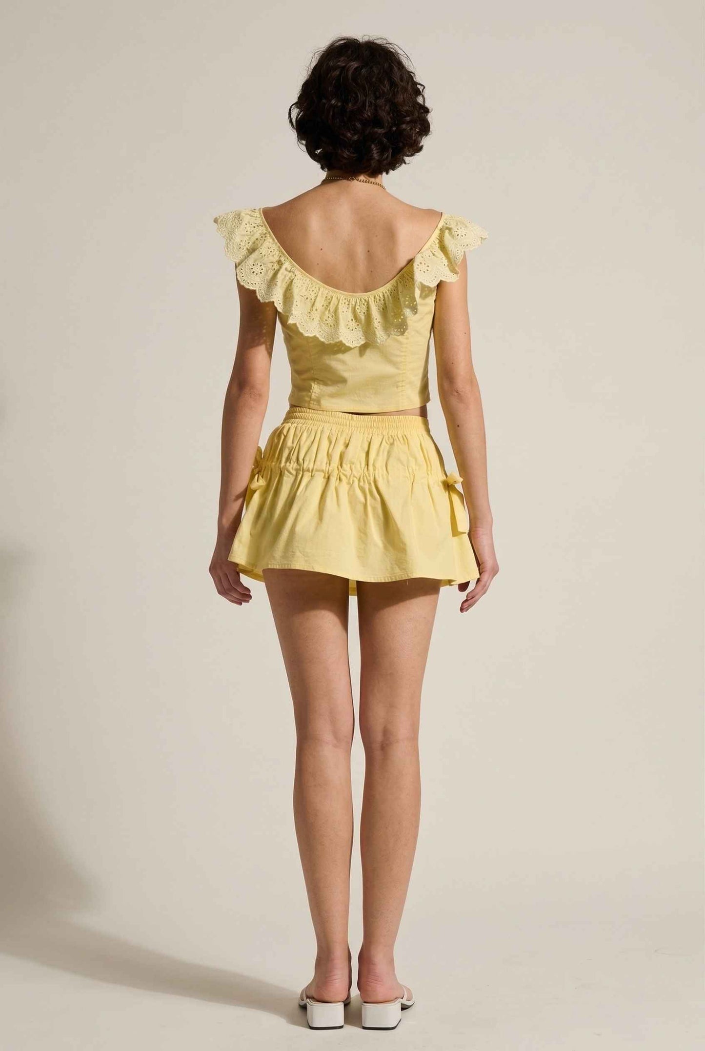 Sunnie Skirt in Soft Yellow Poplin Mini Skirt with Bows paired with matching ruffle top and slip-on sandals