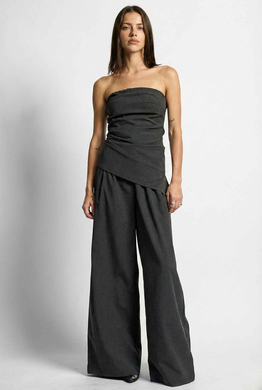 Woman wearing a Sutton Bustier Charcoal Grey Asymmetrical Strapless Top on a white background