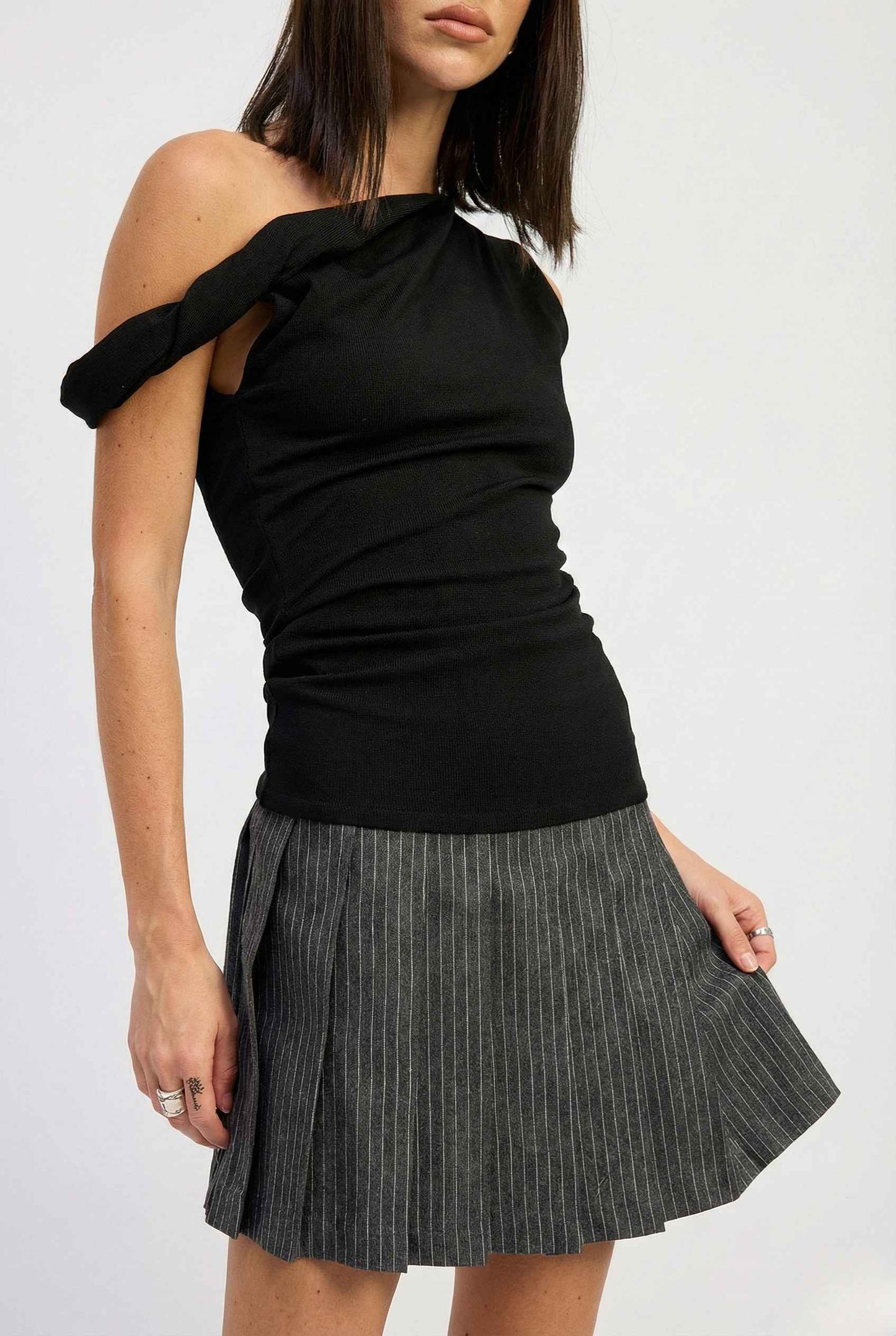 Woman wearing a Sutton Mini Black Asymmetrical Knit & Pinstripe Dress on a white background