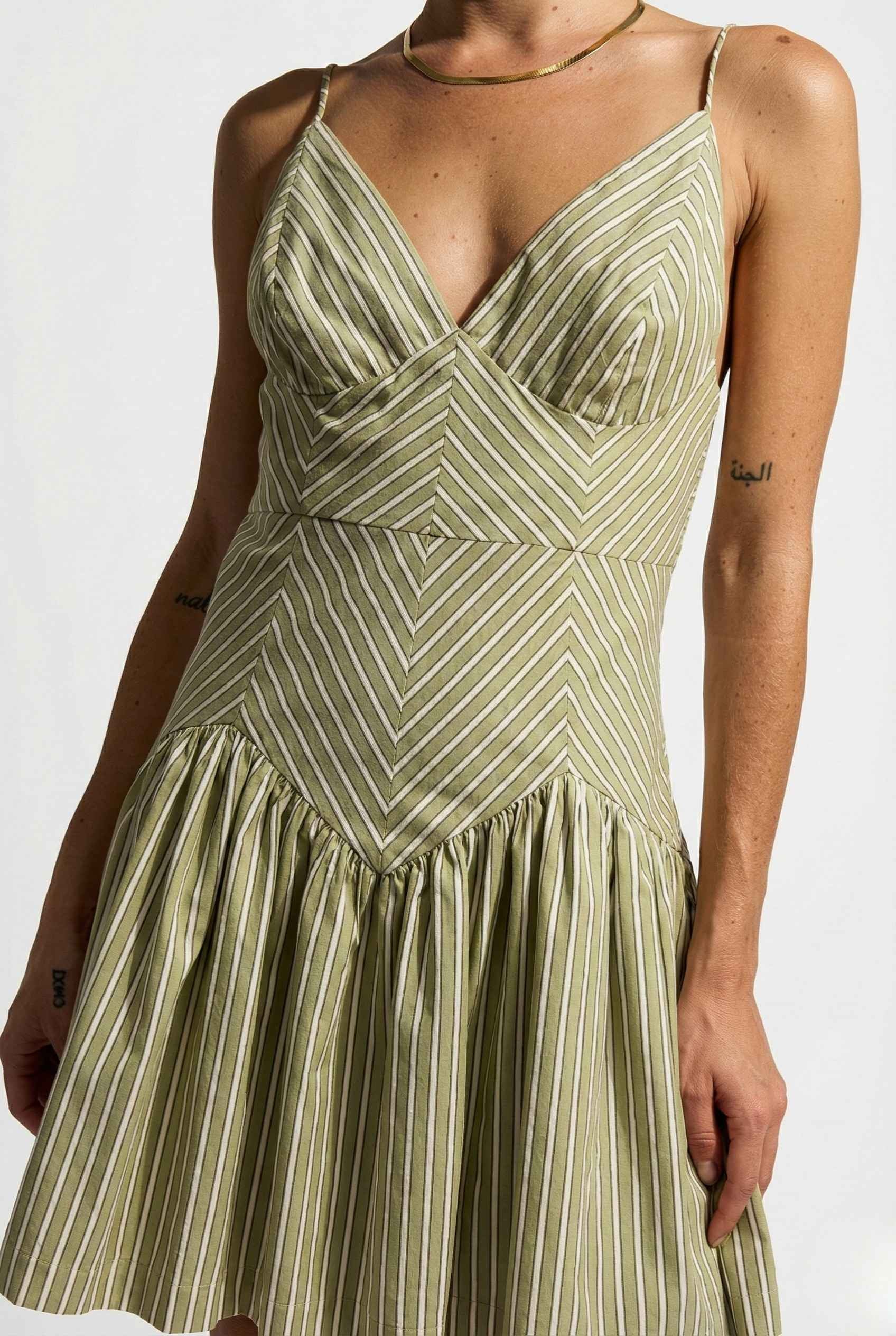 Sutton Mini Sage Stripe Drop Waist Cotton Dress worn by a woman on a white background