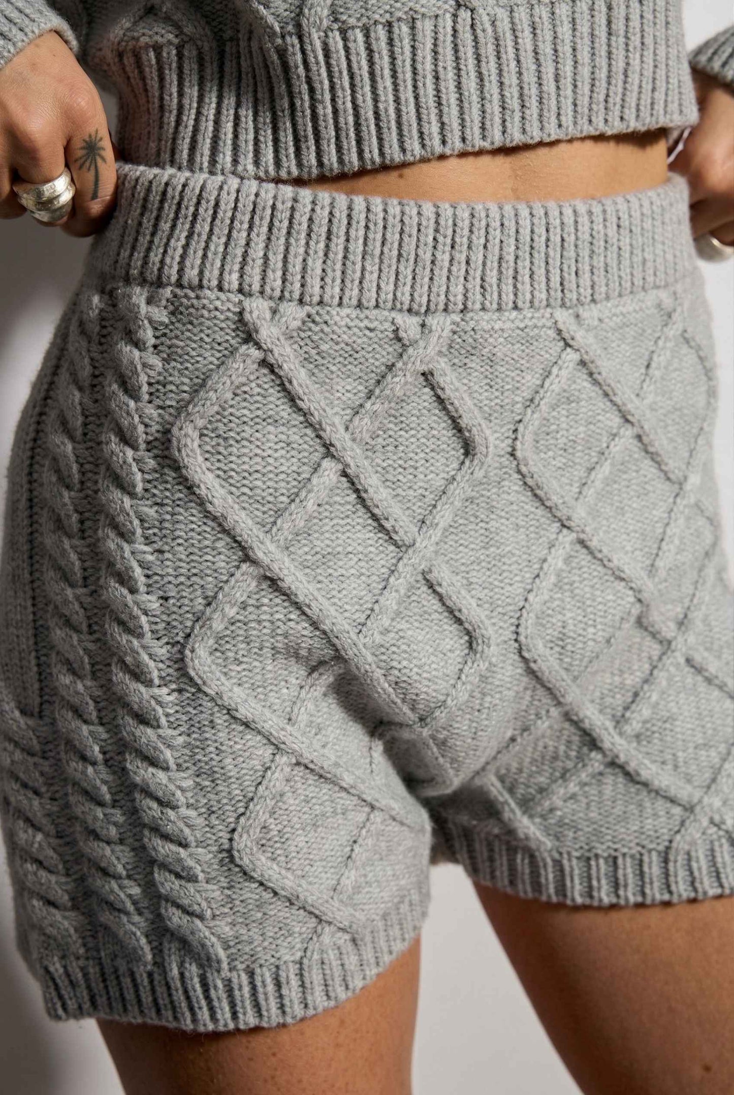Model wearing Sutton Shorts in Grey Cable Knit High-Waist Lounge Shorts paired with matching crop sweater close up argyle pattern