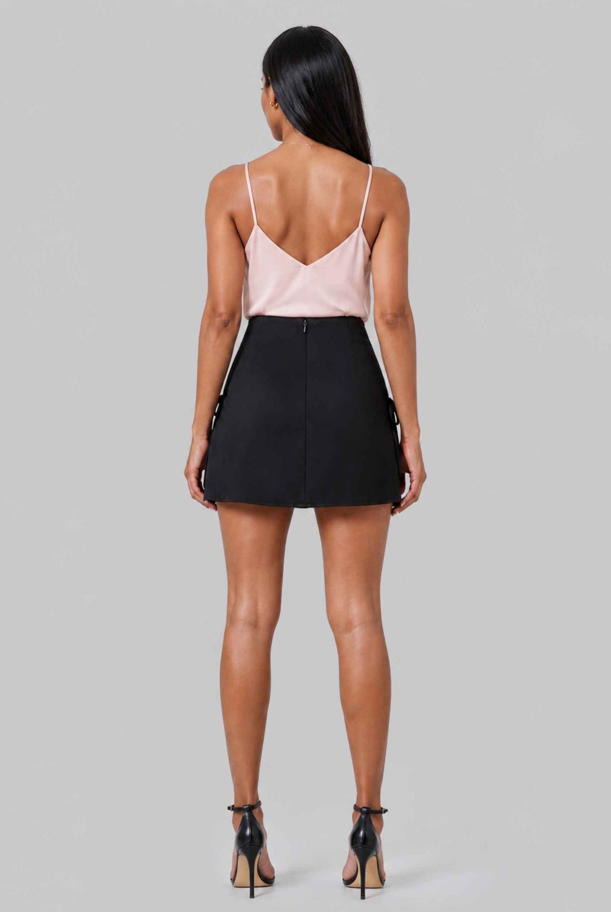 Virtual model wearing The Beau Satin Mini Skirt Tied Bow Detail Satin Mini Skirt in Black