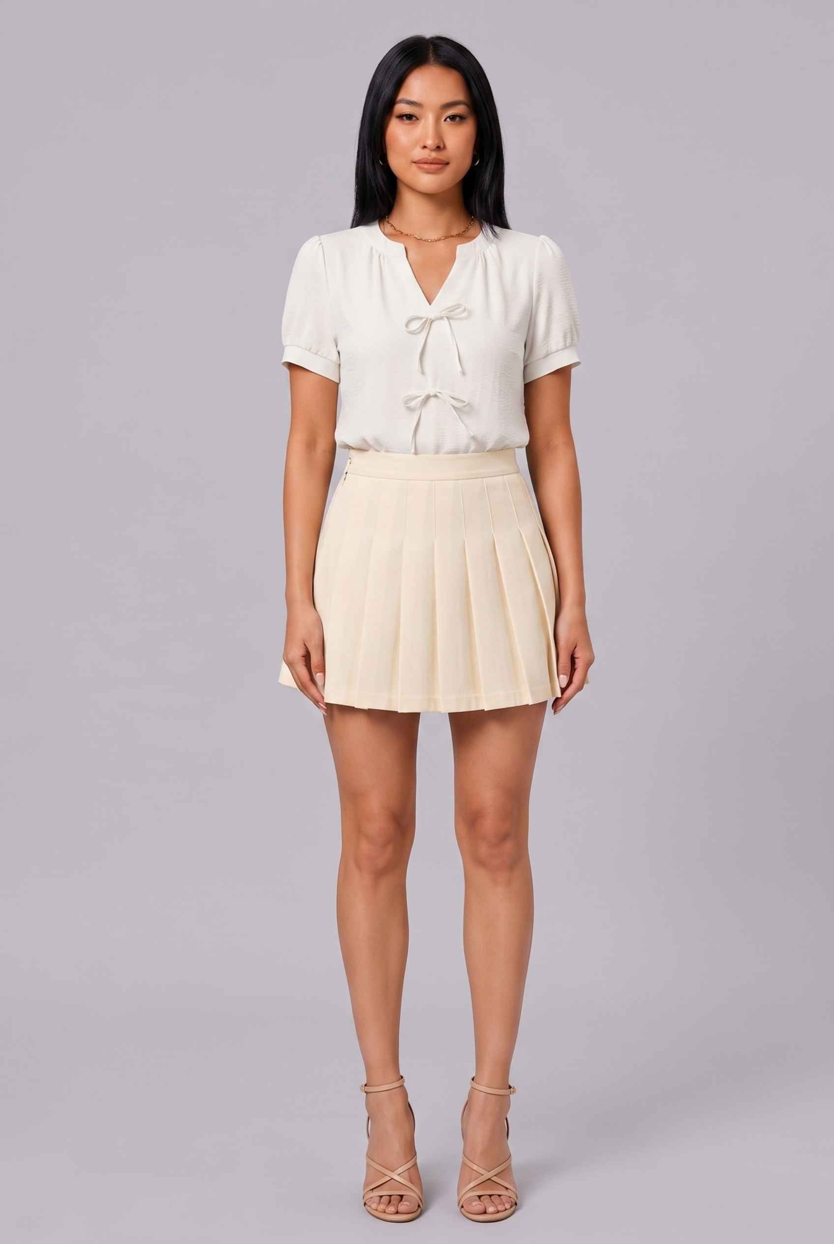 Virtual Model Wearing The Blythe Pleated Mini Skirt Cream High-Waisted Pleated Tennis Mini Skirt