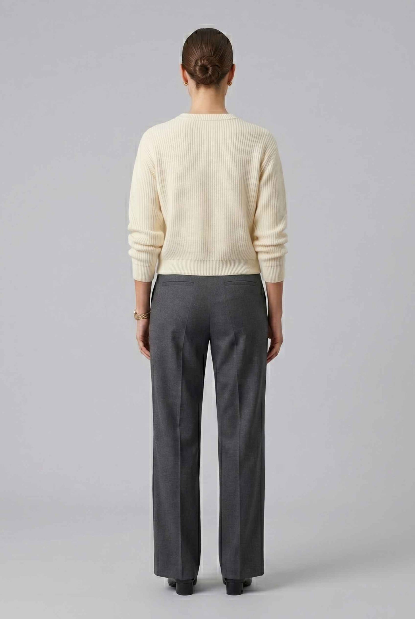 Woman wearing The Camille Bow Cardigan Ribbed Shaker Cream Knit Sweater on a plain background