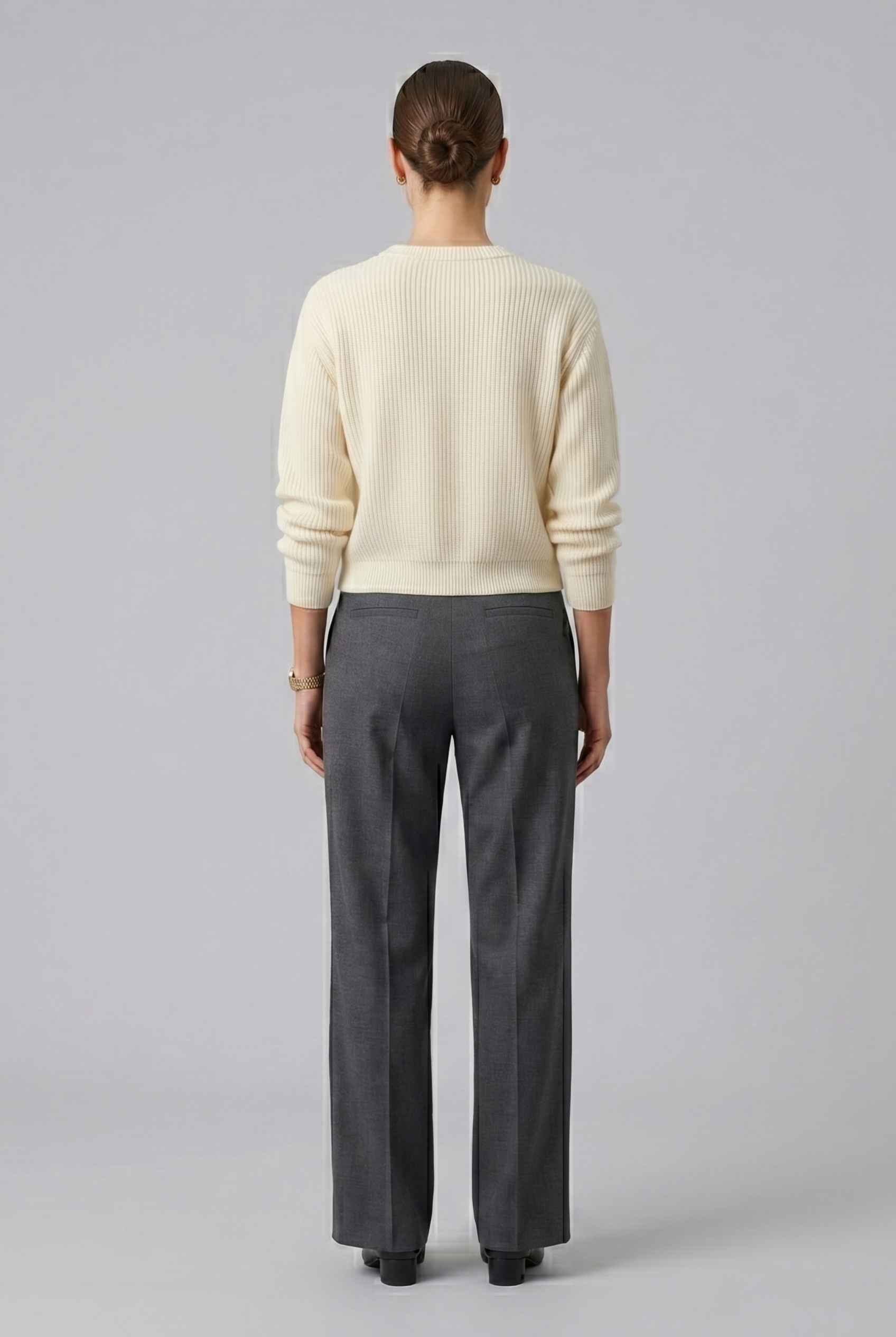 Woman wearing The Camille Bow Cardigan Ribbed Shaker Cream Knit Sweater on a plain background