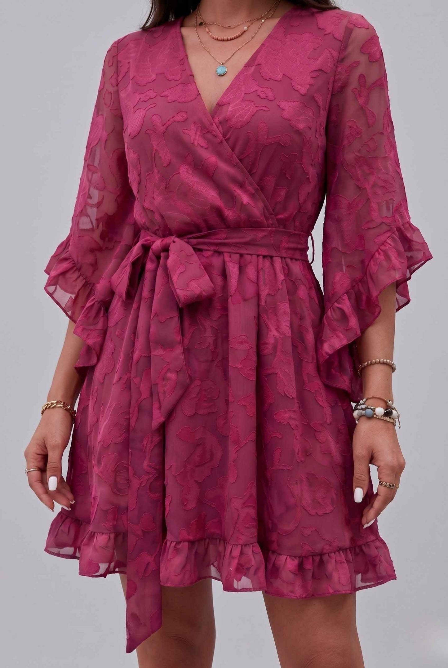 The Cherise Devoré Wrap Dress Jacquard Floral Lace Pink Mini Dress on a gray background