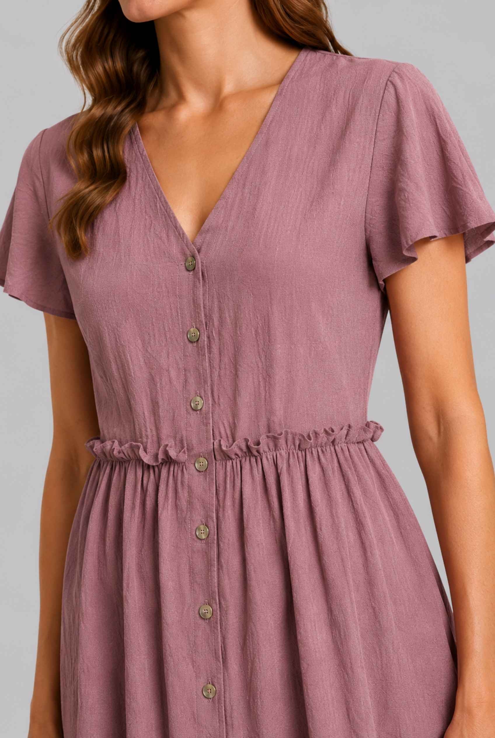 Virtual Model wearing The Delia Buttoned Mini Blush Flutter Sleeve Ruffled Dress