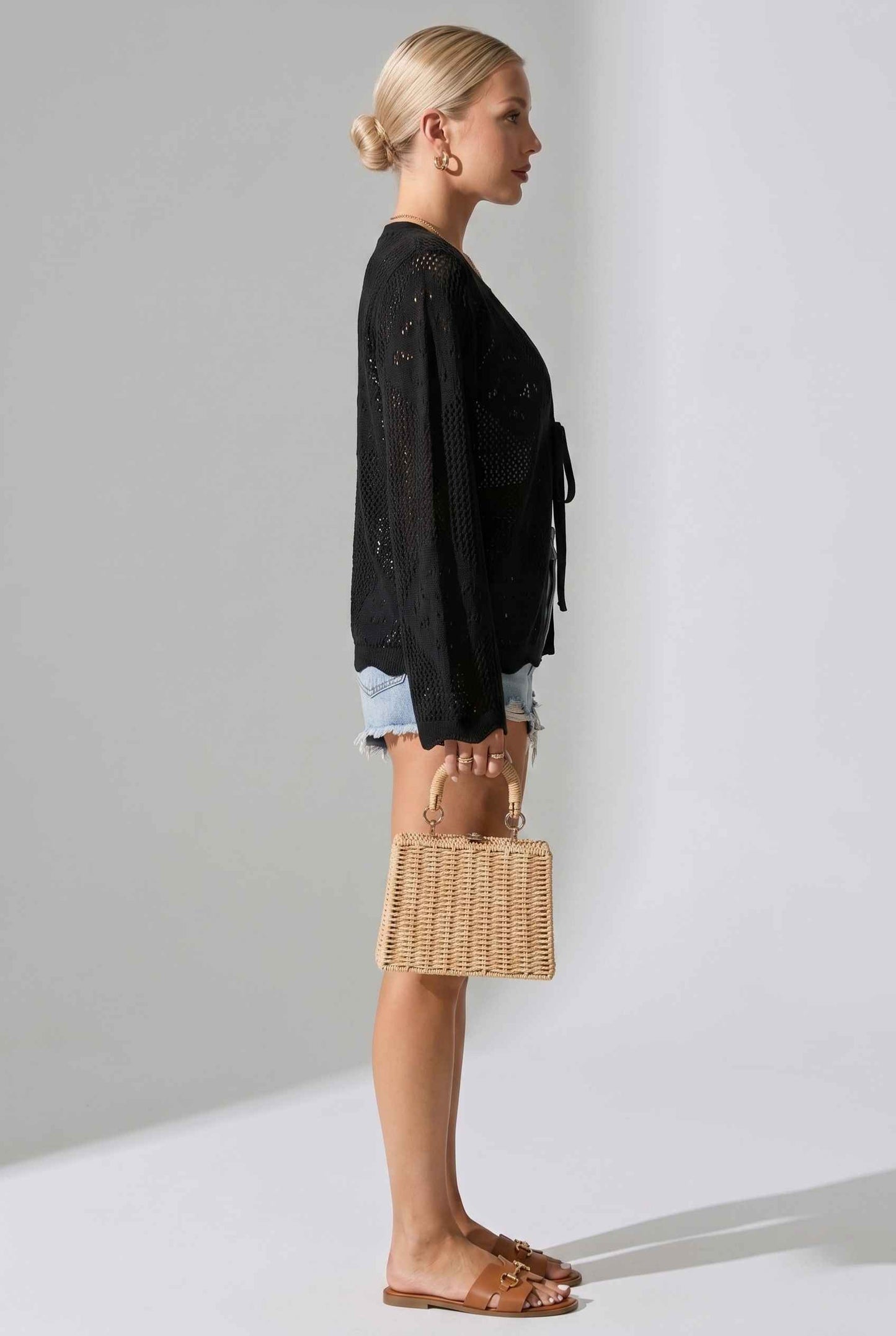Woman wearing a The Faye Tie-Front Cardigan Open Stitch Black Crochet Cardigan against a plain background