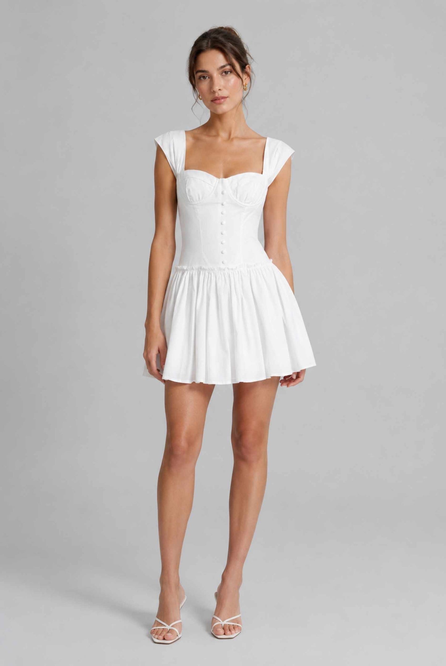 Woman wearing The Iris Poplin Mini Bustier Top White Poplin Dress against a gray background