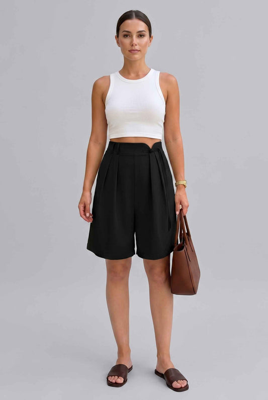 Woman wearing The Kyoto Pleated Short Pleated High Waisted Asymmetrical Black Short on a gray background