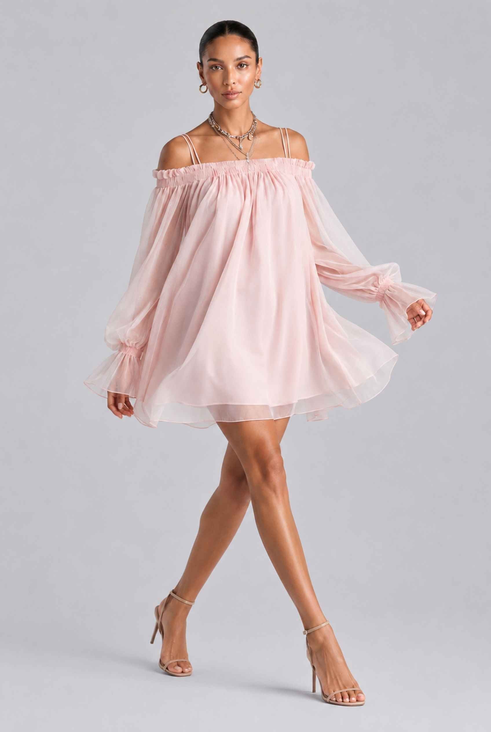 Woman wearing The Lucia Chiffon Dress Off-Shoulder Bishop Sleeve Pink Mini Dress on a gray background