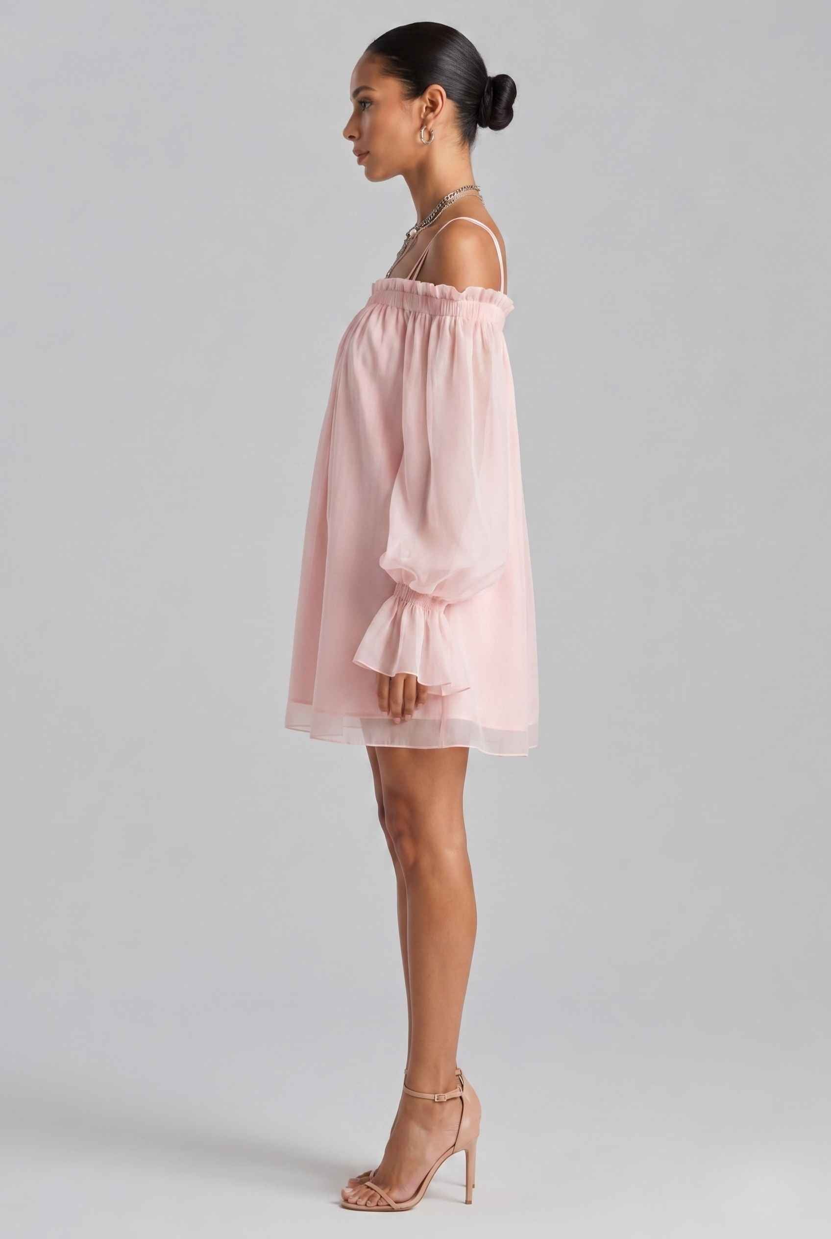 Woman wearing The Lucia Chiffon Dress Off-Shoulder Bishop Sleeve Pink Mini Dress against a plain background