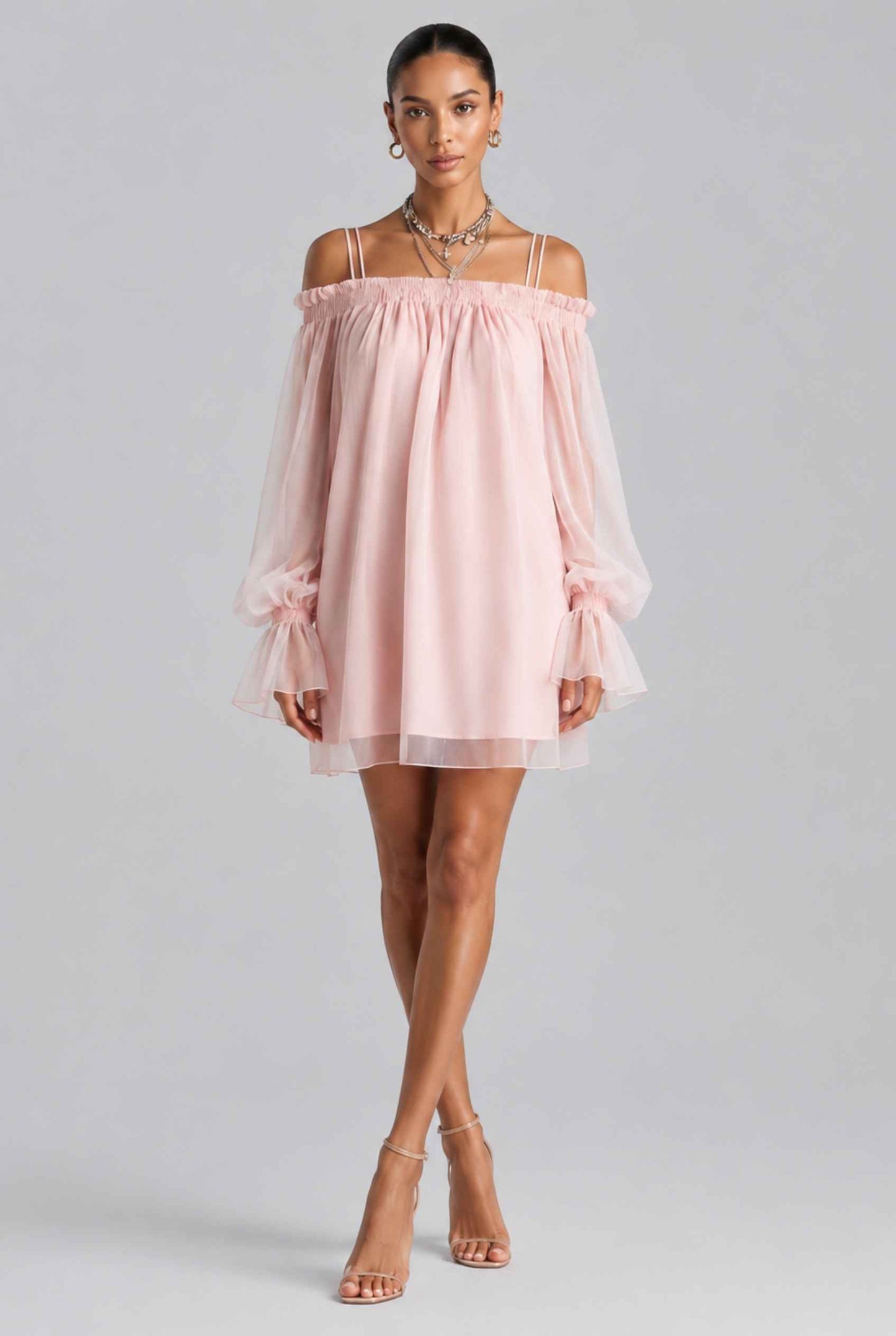 Woman wearing The Lucia Chiffon Dress Off-Shoulder Bishop Sleeve Pink Mini Dress on a gray background