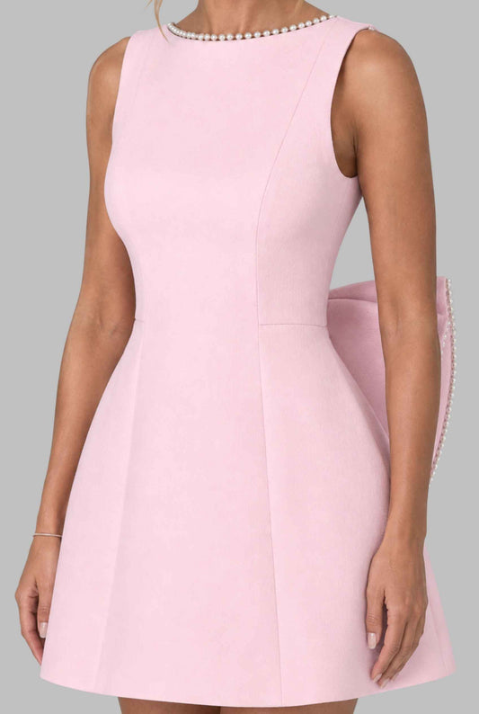 Virtual model wearing  The Noémi Pearl Bow Dress Pearl-Trimmed Statement Bow Mini Dress in Pink