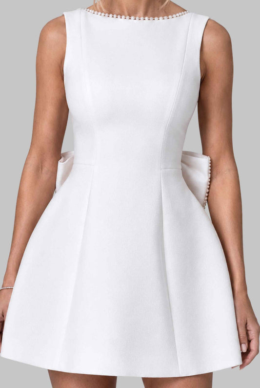 Virtual model wearing  The Noémi Pearl Bow Dress Pearl-Trimmed Statement Bow Mini Dress in White