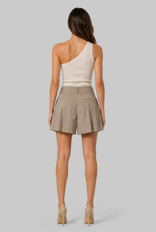 Virtual model wearing The Ottilie Pleated Short Tie-Waist Tailored Shorts in Camel with a tank top and heels on a neutral background
