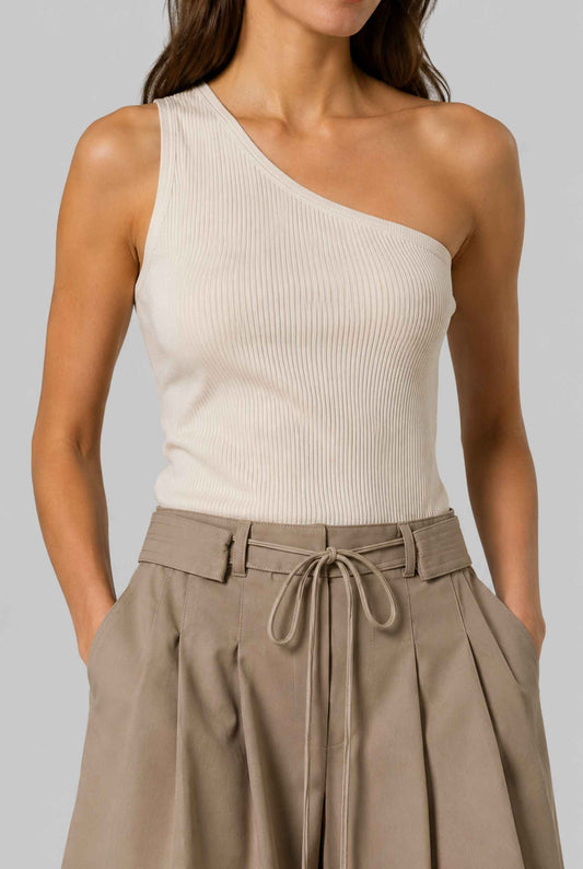 Virtual model wearing The Ottilie Pleated Short Tie-Waist Tailored Shorts in Camel with a tank top and heels on a neutral background