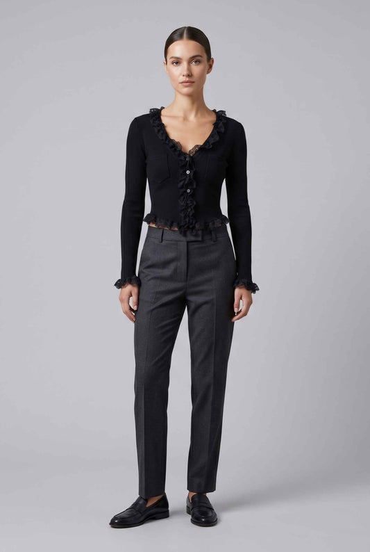 Woman wearing The Rosalie Lace Cardigan Ruffle Ribbed Black Knit Cardigan on a gray background