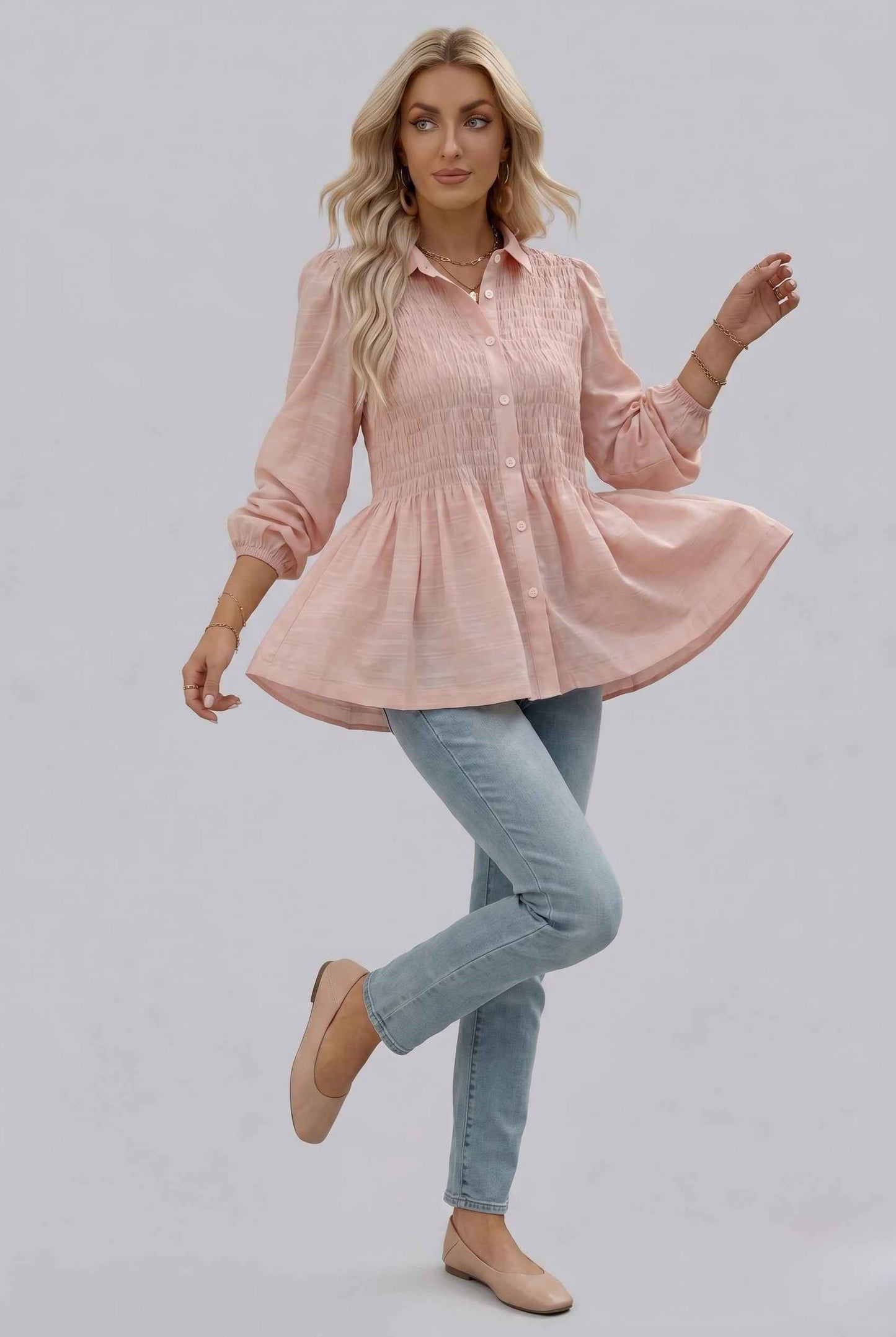 Woman wearing The Sutton Peplum Blouse Smocked Button-Down Blush Pink Top on a gray background
