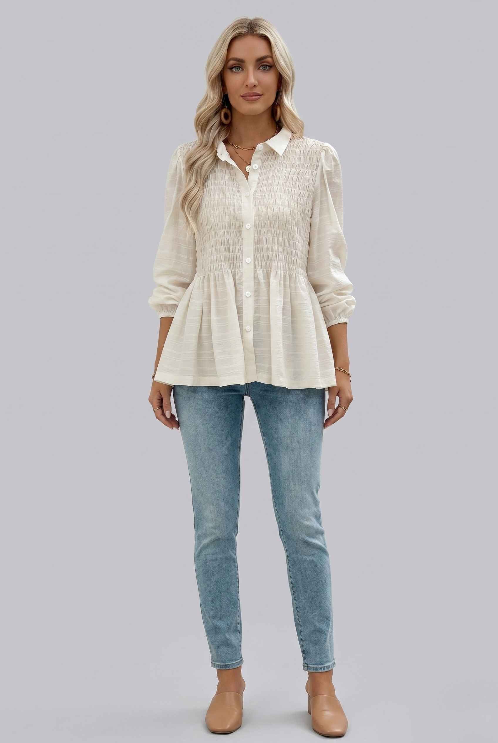 Woman wearing The Sutton Peplum Blouse Smocked Button-Down Off White Top on a gray background