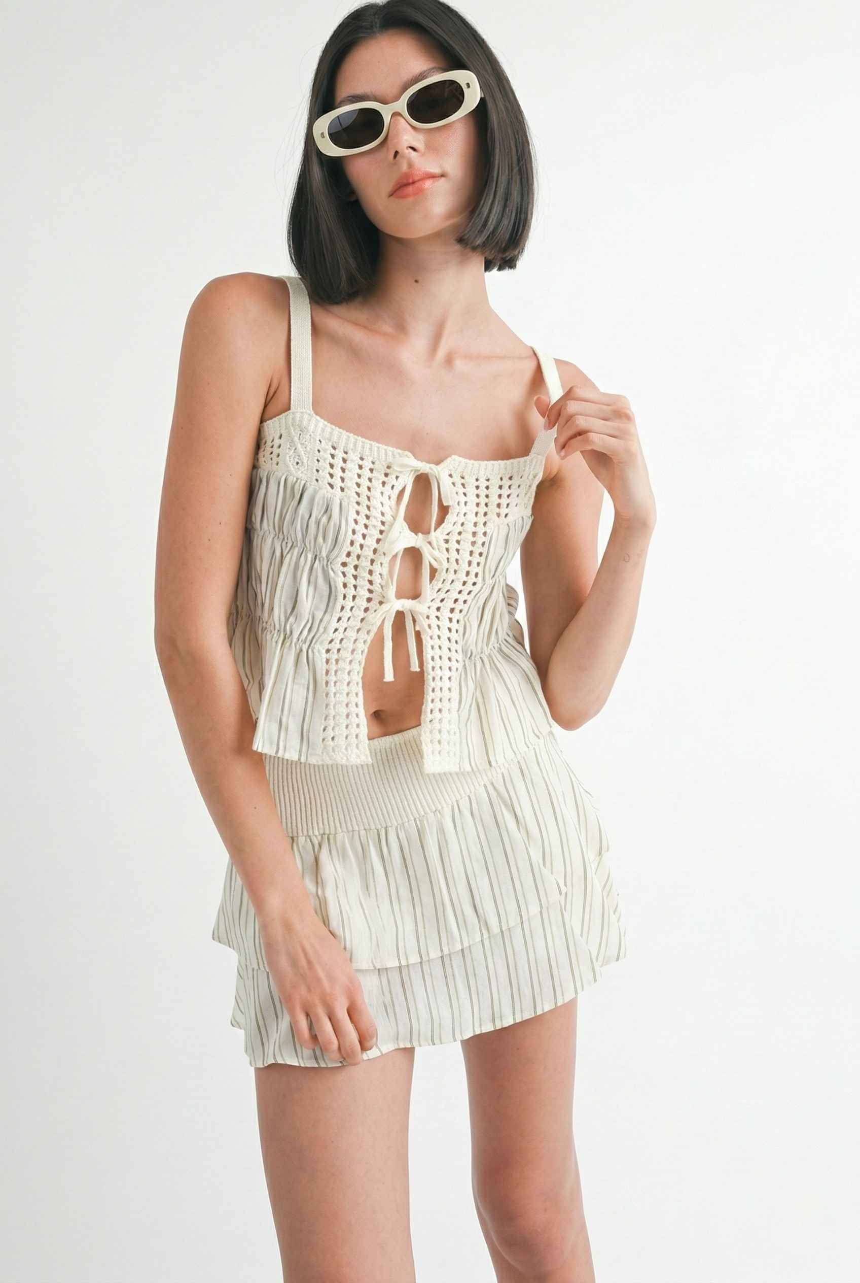Model wearing Thea Top in Ivory Linen-Blend Peplum Cami with Pinstripes paired with matching mini skirt on a plain background