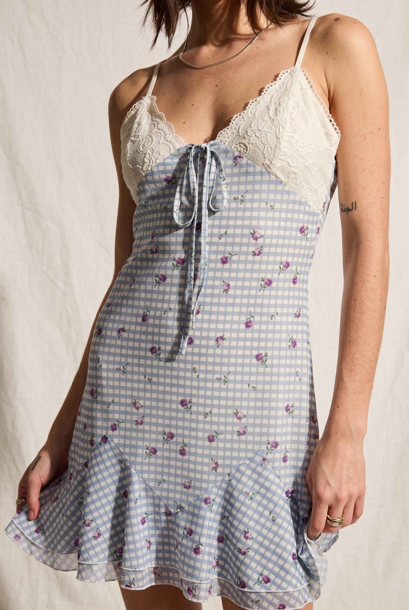 Model wearing Valencia Lace-Trim Gingham Mini Dress Floral Slip Dress in Blue close up lace and tied detail