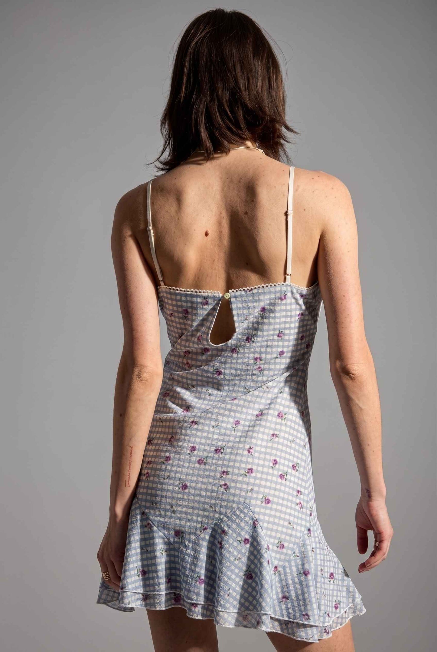 Model wearing Valencia Lace-Trim Gingham Mini Dress Floral Slip Dress in Blue back detail button closure and ruffled hem