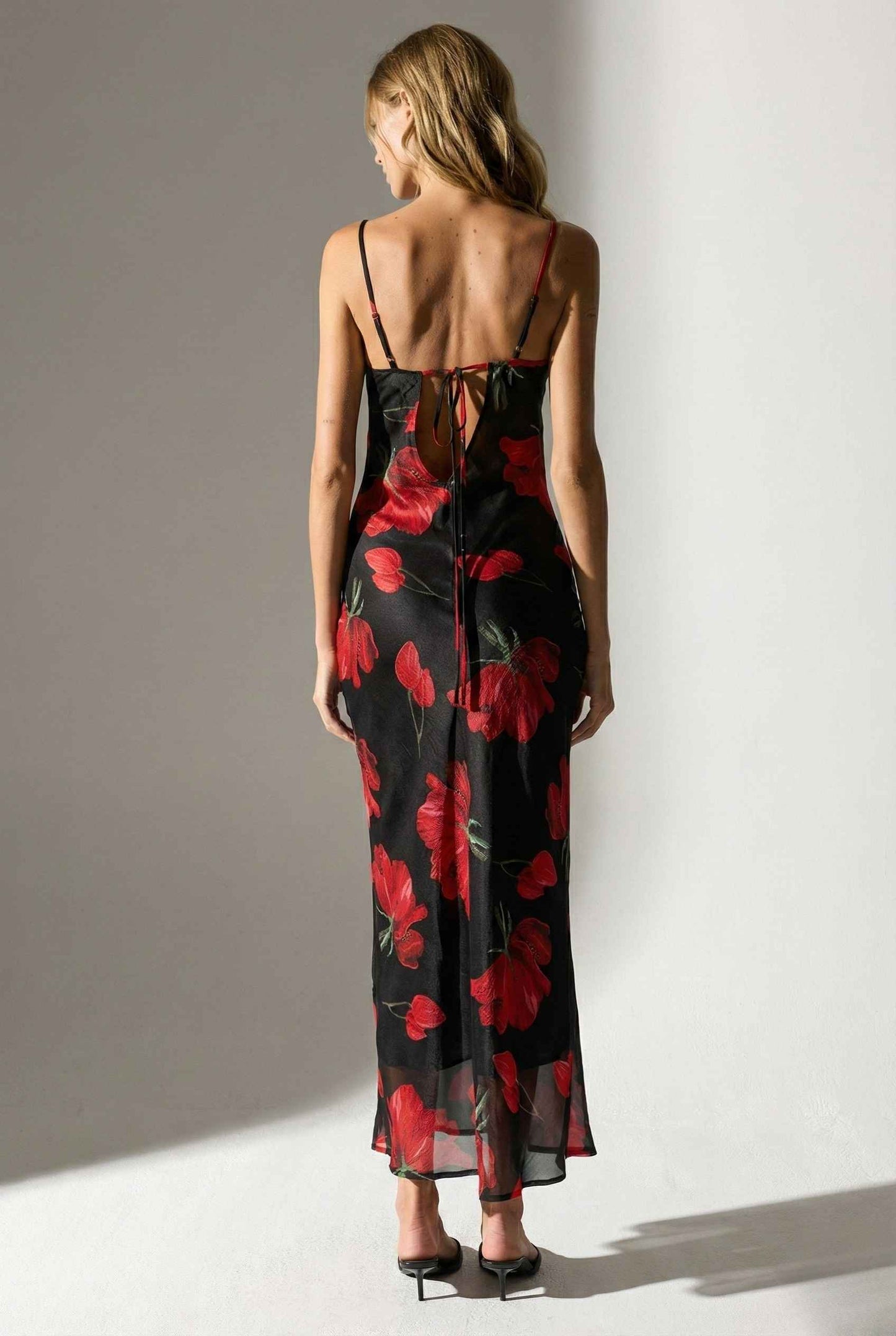 Woman wearing a Valentina Maxi Black Cowl Neck Floral Mesh Dress with red floral patterns against a plain background