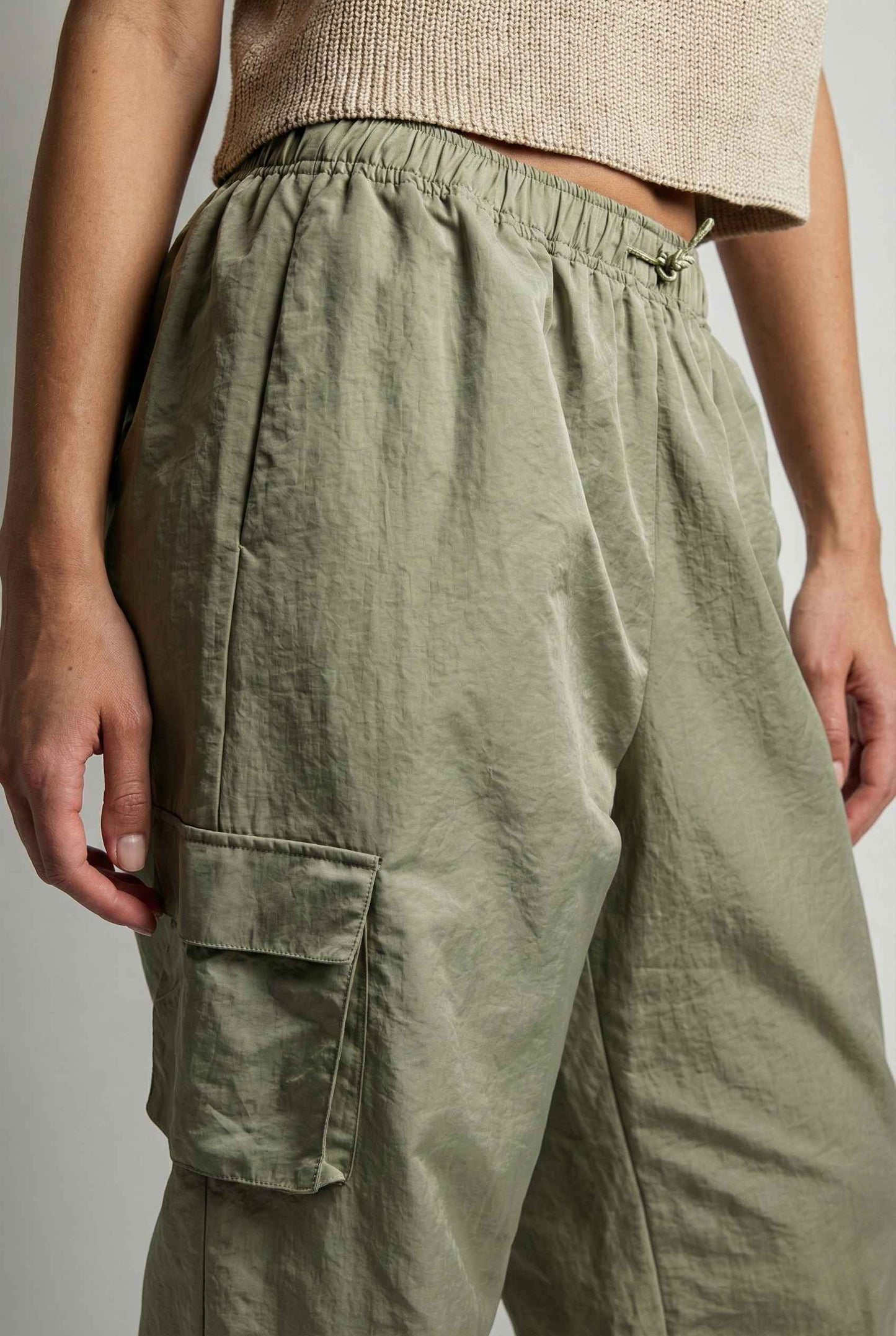 Model wearing Wren Pants 100% Nylon Parachute Cargo Pants in Olive with t-shirt