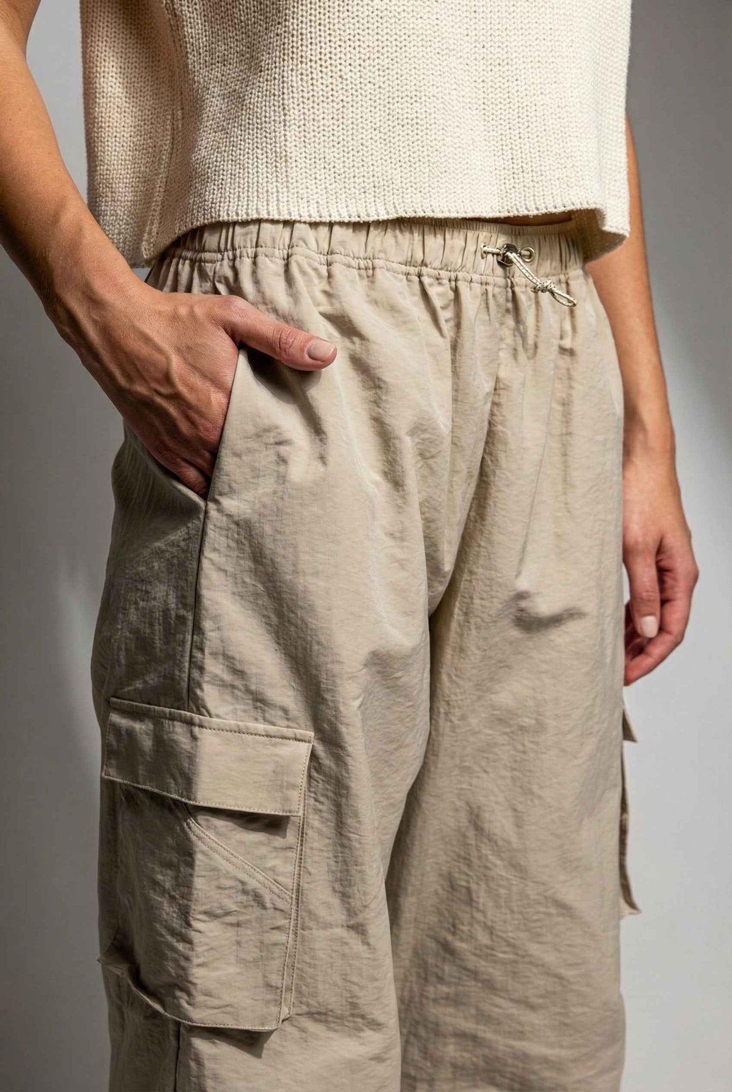 Model wearing Wren Pants 100% Nylon Parachute Cargo Pants in Taupe with t-shirt