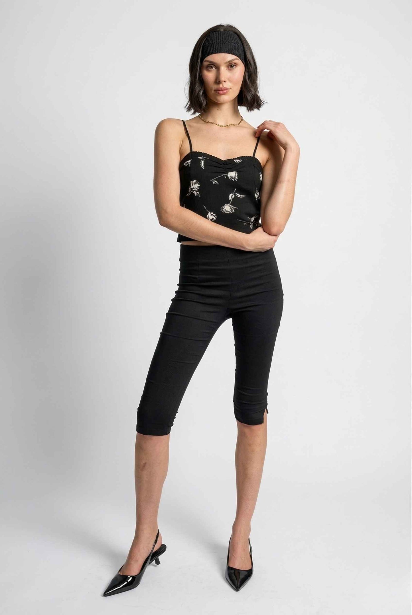 Woman wearing a Zara Top Black & White Rose Print Cotton Lace Trim Camisole and black pants on a white background