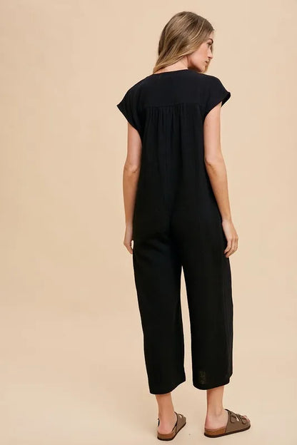 Annie Wear Button Detail Wide Leg Jumpsuit with Pockets in Black, featuring a relaxed fit and cap sleeves