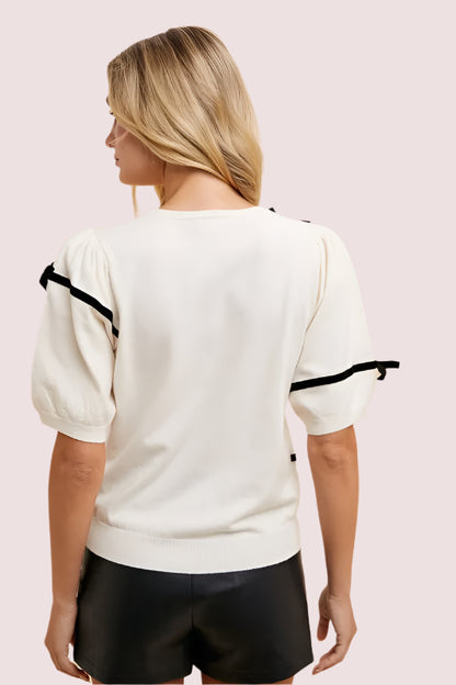 Back view of Annie Wear Striped Bow Round Neck Knit Top featuring puff sleeves and a stylish design