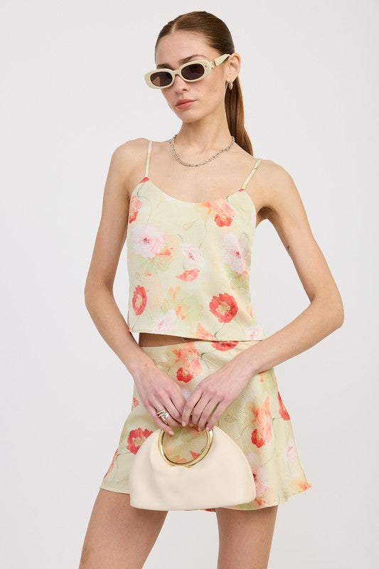 Emory Park floral bias cut mini satin skirt paired with matching spaghetti strap top and cream handbag