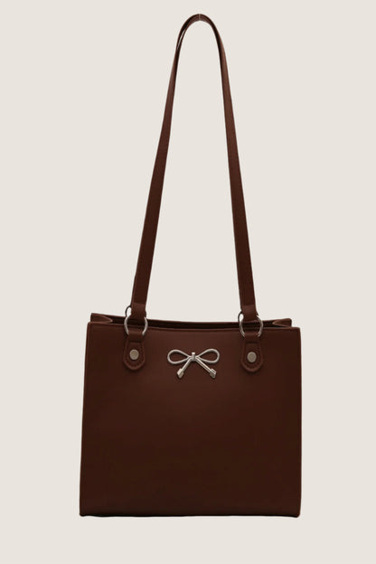 Stylish brown bow detail shoulder bag with adjustable straps and silver accents