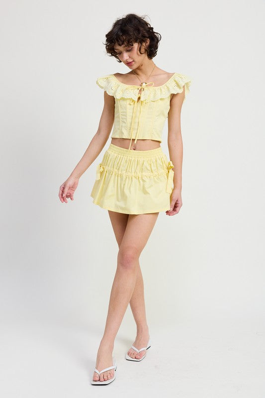 Emory Park Mini Ruched Poplin Mini Skirt in yellow worn with matching cropped top and white sandals