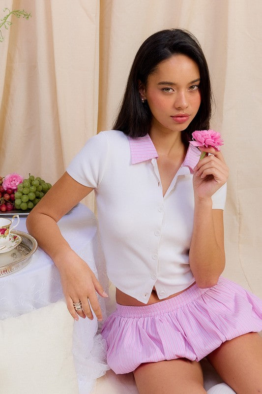 Emory Park button down shirt with contrasted collar in white with pink collar worn by a woman holding a flower