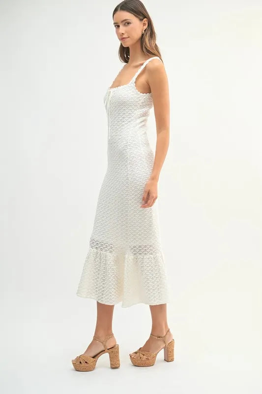 Elegant crochet knit midi dress in white with ruffled hem and thin straps for a stylish summer look