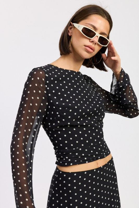 Model wearing a Cropped Polka Dot Sheer Top with long sleeves and stylish sunglasses by Emory Park