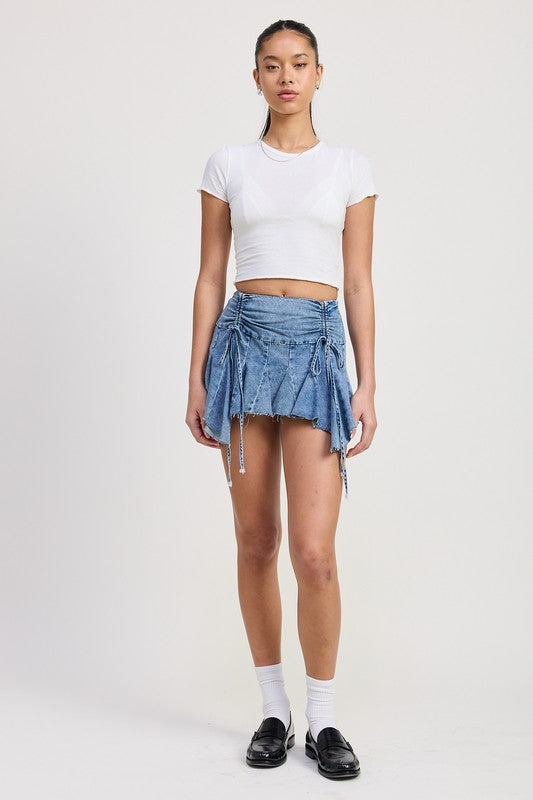 Emory Park Ruffle Mini Skirt in denim with drawstring details worn with white crop top and black loafers