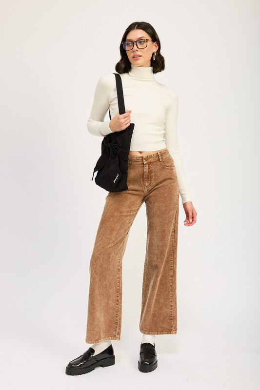 Emory Park Distressed Corduroy Pants in tan on model paired with cream turtleneck and black loafers