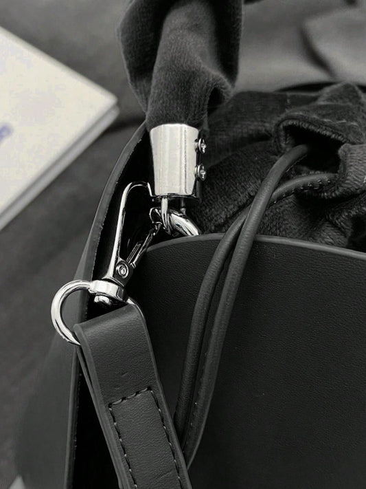 Close-up of drawstring bucket bag with a secure metal clasp and adjustable strap