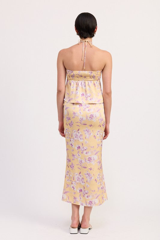 Back view of model wearing Emory Park floral print ruched midi skirt in yellow with purple flowers