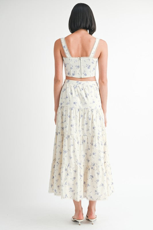 Back view of a woman wearing Emory Park Floral Tiered Maxi Skirt with a matching crop top and white heels