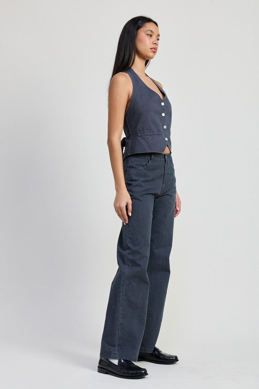 Woman wearing Emory Park Folded Fitted Denim Pants in dark wash paired with a sleeveless buttoned vest