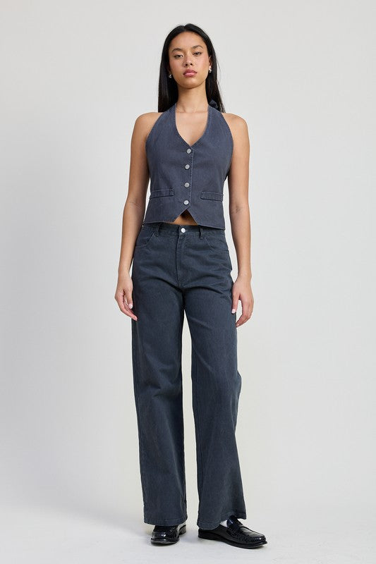 Woman wearing folded fitted denim pants in dark wash paired with a sleeveless button-up vest by Emory Park